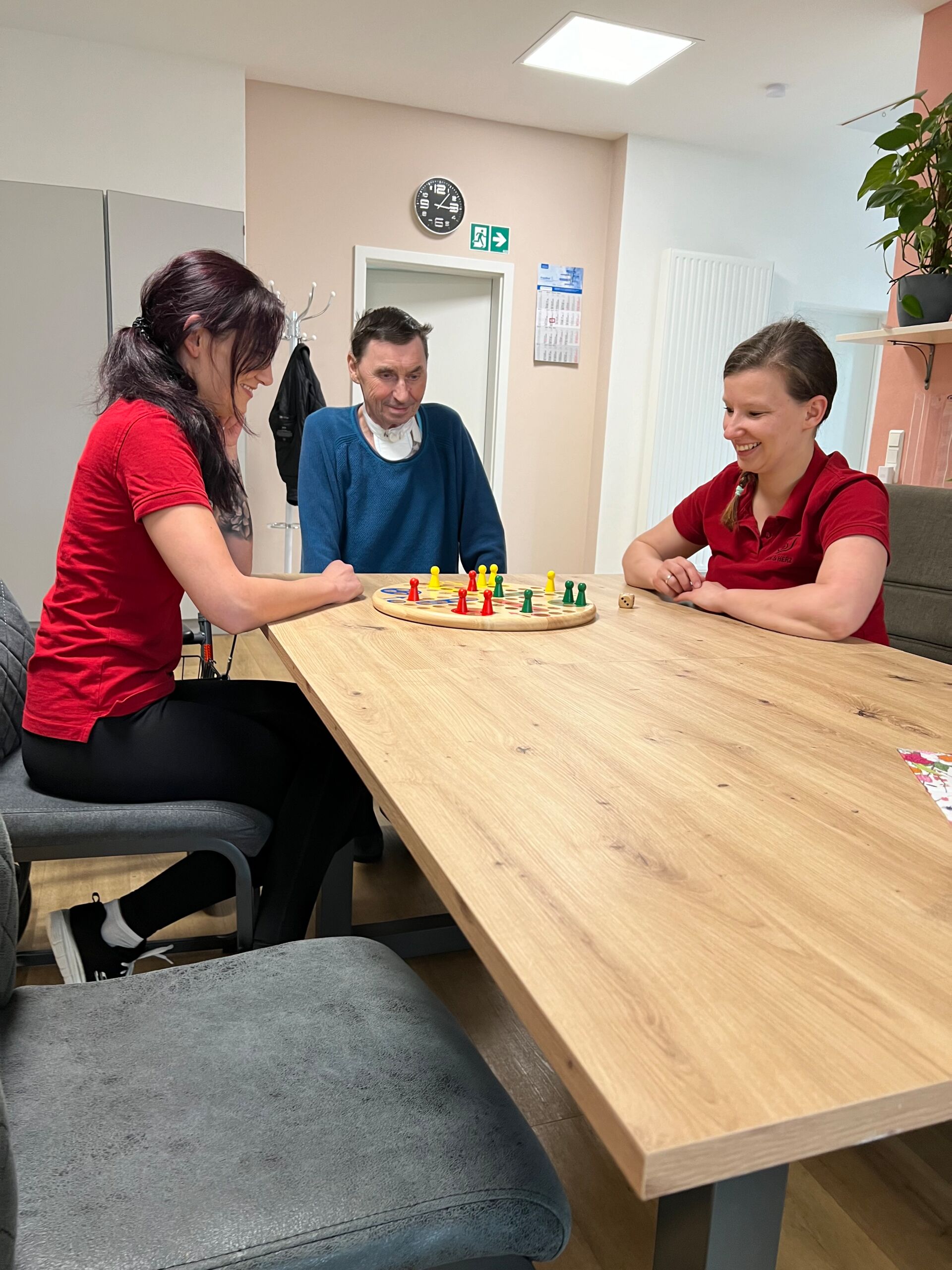 Zwei Krankenschwestern spielen ein Spiel mit einem Patient in der Wohngemeinschaft Brand-Erbisdorf